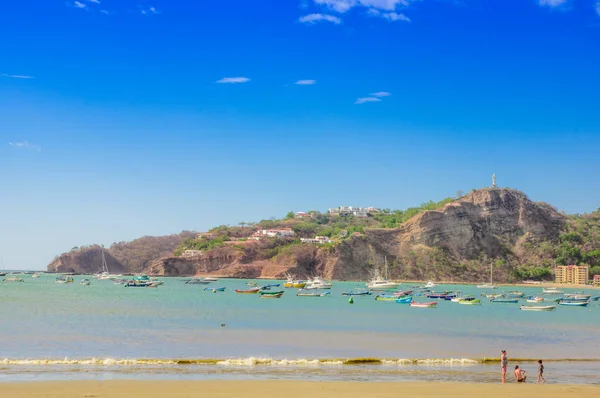 Beautiful outdoor view of some boats in the water with restaurants and hotels on pacific ocean beachfront scene San Juan del sur — Stock Photo, Image