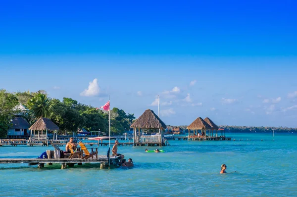 Quintana Roo, Mexico, mei, 29, 2018: Niet-geïdentificeerde mensen genieten van een houten pier en huizen de Laguna Bacalar, Chetumal, Quintana Roo — Stockfoto