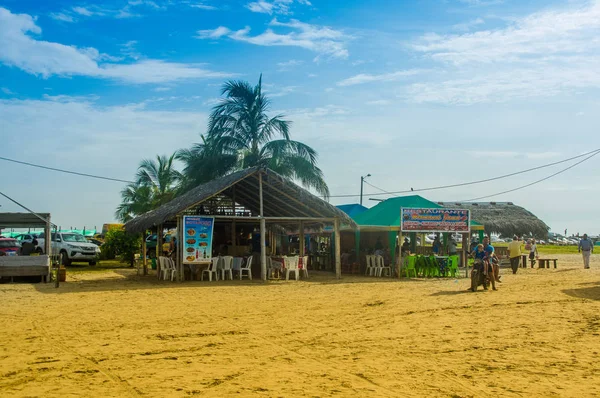 MANABI, ECUADOR - 29 DE MAYO DE 2018: Turistas no identificados comiendo en un edificio de cabañas en la playa de Cojimies, durante un día soleado en Manabí — Foto de Stock