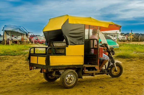 MANABI, ECUADOR - 29 DE MAYO DE 2018: Hombre no identificado conduciendo su triciclo sobre la arena amarilla y disfrutando del hermoso paisaje natural de la playa de Cojimies —  Fotos de Stock