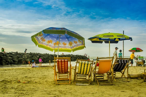 Manabi, Ekvator - 29 Mayıs 2018: sandalye ve güneşten korumak ve güzel doğal peyzaj Cojimies Beach, Manabi zevk unbrellas ile sahilde yürüyüş tanımlanamayan turist — Stok fotoğraf