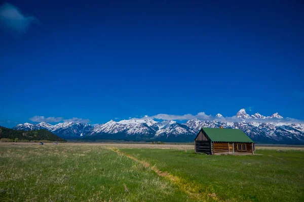 stock image Old mormon barn in Grand Teton Mountains with low clouds. Grand Teton National Park, Wyoming