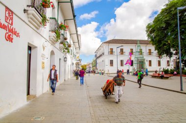 Popayan, Kolombiya - 06 Şubat 2018: Kimliği belirsiz kişi şehirde beyaz binalar ile Popayan kasaba sokaklarında yürürken açık görünüm