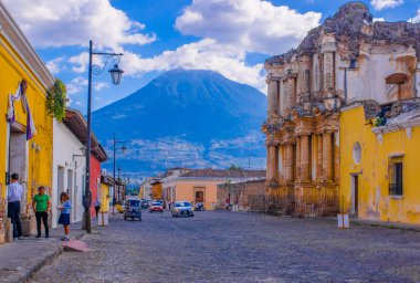 Ciudad de Guatemala, Guatemala, Nisan, 25, 2018: eski binalar ve arka planda Agua volkan çevreleyen kenti antigua, bir tonda kaldırım sokak üzerinde bekleyen bazı araçları ile