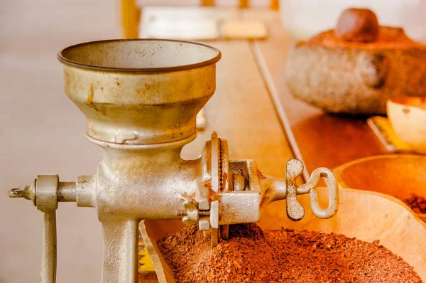 Gros plan de fèves de cacao et de cacao broyés sur une table en bois, avec moulin à main, dans un fond flou — Photo