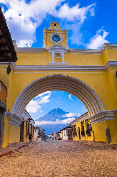 Antigua, guatemala - 25. märz 2013: der berühmte bogen des stadtzentrums von antigua zusammen mit touristen und händlern von kunst und handwerk. — Stockfoto