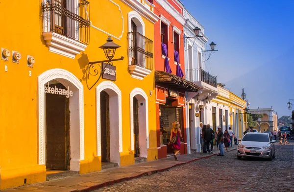 Ciudad de Guatemala, Guatemala, 25 de abril de 2018: Vista al aire libre de la perspectiva de esquina de una casa colonial de color amarillo brillante con ventanas con rejas en la ciudad de Antigua — Foto de Stock