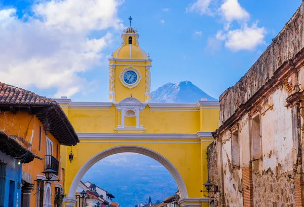 ANTIGUA, GUATEMALA - MARCH 25 2013: The famous arch of the city center of Antigua together with tourists and vendors of arts and crafts. — Stock Photo, Image