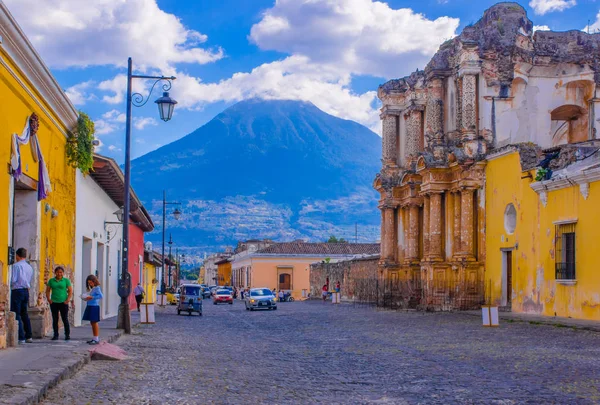危地马拉, 危地马拉, 25, 2018: 安提瓜和巴布达的看法, 一些汽车等待在一个色调的人行道街, 周围的旧建筑, 和在背景的阿尔多火山 — 图库照片