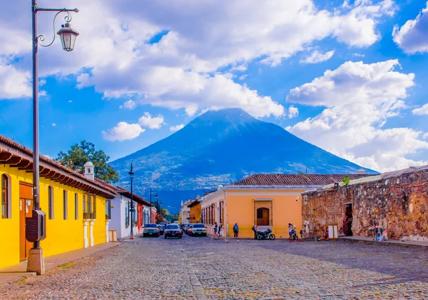 危地马拉, 危地马拉, 25, 2018: 安提瓜和巴布达的看法, 一些汽车等待在一个色调的人行道街, 周围的旧建筑, 和在背景的阿尔多火山 — 图库照片
