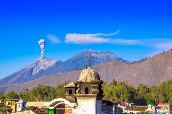 Όμορφο τοπίο τεράστιο βουνό στη διαδικασία aruption με μια στήλη στάχτης, θέα από τις στέγες του κτιρίου στην πόλη της Αντίγκουα στην πανέμορφη ηλιόλουστη ημέρα και μπλε του ουρανού — Φωτογραφία Αρχείου