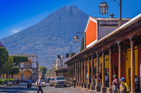Ciudad de Guatemala, Guatemala, 25 de abril de 2018: rua de envolvimento apedrejado e pessoas caminhando e desfrutando do lindo dia ensolarado da cidade de Antígua e do vulcão Água no fundo Guatemala — Fotografia de Stock