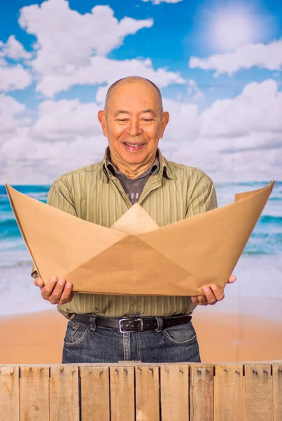 Gros plan de l'homme mûr avec bateau en papier brun origami, concept pour les aspirations, leadership, stratégie ou tout simplement l'ennui dans le bureau — Photo