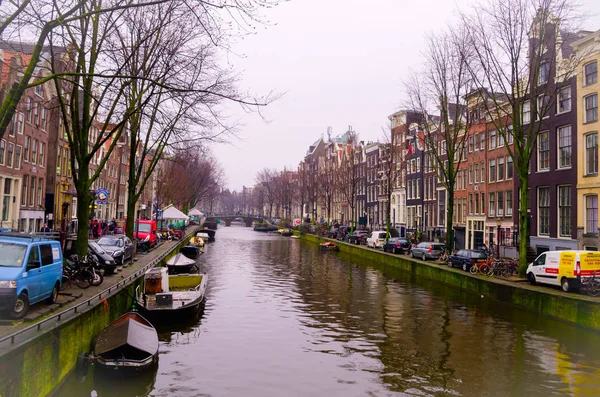 Amsterdam, Niederlande, 23. April 2018: Blick auf einige Autos in der Straße in der Nähe von vielen Booten in den Kanälen von amsterdam geparkt, ist die Hauptstadt und bevölkerungsreichste Stadt der Niederlande — Stockfoto