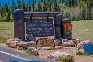 Büyük Kanyon, Arizona ABD, Haziran, 14, 2018: Ahşap bilgilendirici işareti ve yol açık görünümü Grand Canyon Park bir girişinde bükülmüş
