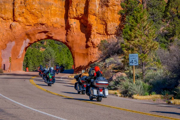 BRYCE CANYON, UTAH, JUNE, 07, 2018: Outdoor view of motorcyclists in the road crossing throught the red arch road tunnel on the way to Bryce Canyon National Park, Utah — Stock Photo, Image