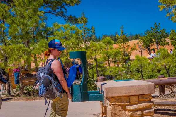 BRYCE CANYON, UTAH, JUNHO, 07, 2018: Mulher não identificada vestindo chapéu e roupas confortáveis, enchendo sua garrafa térmica de plástico azul em um reabastecimento de água para uma viagem ao redor do Parque Nacional Bryce Canyon, Utah — Fotografia de Stock