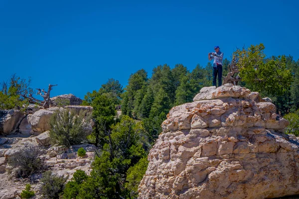 Wielki Kanion, Arizona Usa, 14 czerwca 2018 r.: Dwie kobiety wycieczkowicz stoi na stromym klifie przejęcie w niesamowity widok słynnego Wielkiego Kanionu w piękny słoneczny dzień z niebieski niebo latem w Arizonie — Zdjęcie stockowe