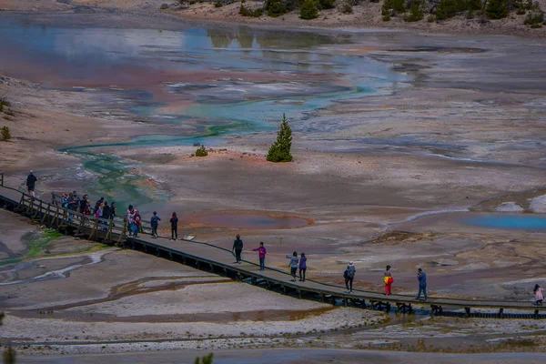 Vista superior de las personas que caminan en el paseo marítimo entre piscinas y géiseres. El estéril lavabo de color nieve. Cuenca de Porcelana de Norris Geyser Basin, Parque Nacional de Yellowstone, Wyoming — Foto de Stock