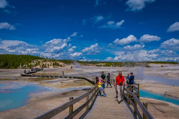 YELLOWSTONE, MONTANA, USA 02 DE JUNIO DE 2018: Personas no identificadas tomando fotos y disfrutando de las piscinas de coloridos puntos de agua de la cuenca Norris Geyser en el Parque Nacional Yellowstone — Foto de Stock