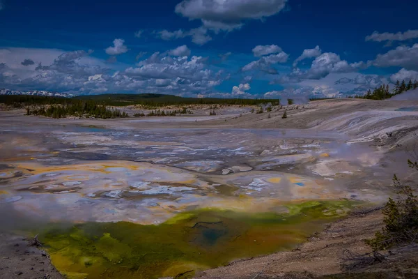 Piscinas térmicas opacas a vapor na bacia de Norris Geyser. Yellowstone National Park, Wyoming, em belo céu azul e dia ensolarado — Fotografia de Stock