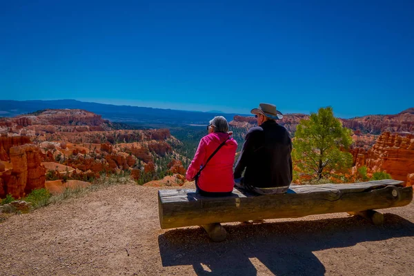 BRYCE CANYON, UTAH, JUNE, 07, 2018: Unidentified people sitting over a log, and enjoying the great spires by erosion in Bryce Canyon National Park, Utah Stock Photo