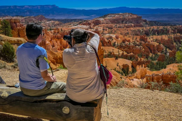 BRYCE CANYON, UTAH, JUNE, 07, 2018: Unidentified people sitting and looking at landscape in Bryce Canyon national park, Utah Stock Picture