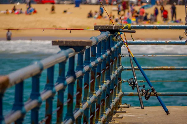 Los Angeles, California, USA, JUNE, 15, 2018: Outdoor view of fishing rods standing in a wooden pier used for people that usually fishing in the pier of Santa Monica — Stock Photo, Image