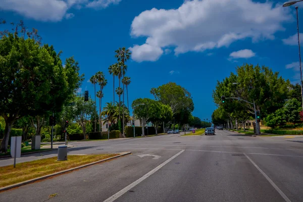 Los Angeles, California, USA, JUNE, 15, 2018: Palm trees street in Beverly Hills and cars circulating in the roads of Los Angeles, California, USA, is famous avenue and celebrities homes — Stock Photo, Image