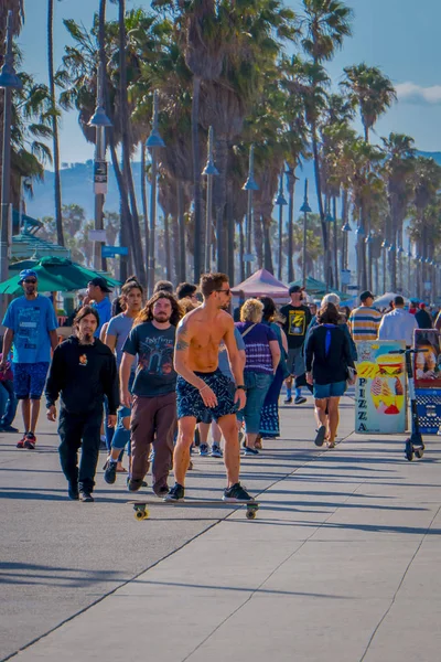 Los Angeles, Kalifornie, Usa, 15 června 2018: Venkovní pohled neznámých lidí pěšky podél Venice Beach a mladý skateboardista s jeho skate v cestu pěšky — Stock fotografie