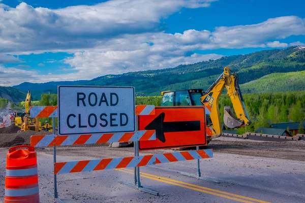 PARQUE NACIONAL DE YELLOWSTONE, WYOMING, EE.UU. - 07 DE JUNIO DE 2018: Señal informativa de carretera cerrada con equipo estacionado en una zona de construcción en el Parque Nacional de Yellowstone —  Fotos de Stock