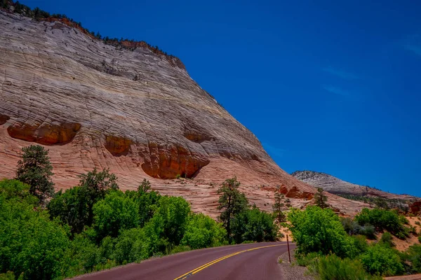 Вид на красный асфальт живописной дороги среди живописных гор оранжевого и красного песчаника — стоковое фото