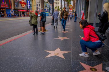 Los Angeles, Kaliforniya, ABD, Haziran, 15, 2018: poz ve Los Angeles'ta şöhret kaldırımı fotoğraf çekmeye tanımlanamayan turistler. Hollywood Walk of Fame 2500'den fazla yıldız celibrity adları özellikleri