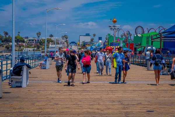 Los Angeles, California, USA, JUNE, 15, 2018: Unidentified people walking in a wooden pier in Santa Monica, at the end of Route 66. The amusement park is a world famous tourist attraction — Stock Photo, Image