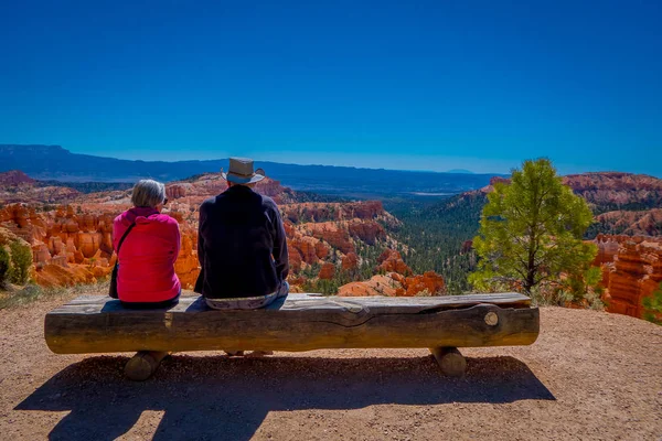 BRYCE CANYON, UTAH, JUNE, 07, 2018: Unidentified people sitting over a log, and enjoying the great spires by erosion in Bryce Canyon National Park, Utah Stock Photo