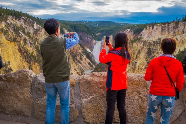 YELLOWSTONE NATIONAL PARK, WYOMING, USA - JUNE 07, 2018: people using their devices to take pictures of the beautiful upper Yellowstone Falls in Yellowstone National Park, Wyoming — Stock Photo, Image