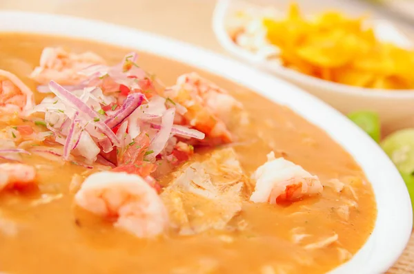 Primer plano del enfoque selectivo de la comida ecuatoriana: cebiche de camarones con un fondo borroso de chifles — Foto de Stock