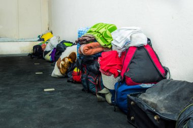 Quito, Ekvator, 21 Ağustos 2018: Renkli elbise, çanta ve aksesuarları kendi ülke Amerika Birleşik Devletleri üzerinden kaçış insanlar için bir sığınma merkezi içinde bir oda zemin yığını