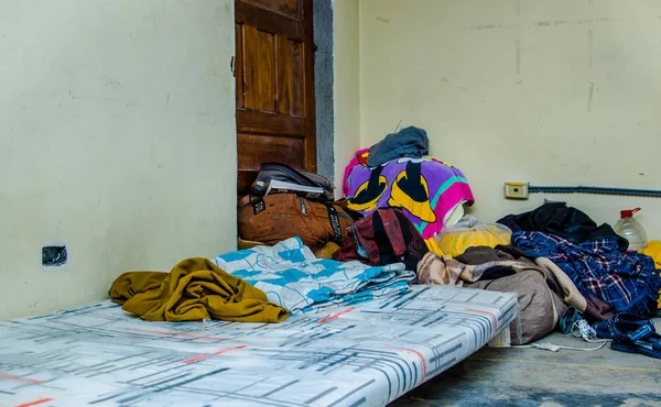 Quito, Ekwador, 21 sierpień 2018: Kupie kolorowe ubrania i akcesoria w ziemi w pomieszczeniu wewnątrz centrum schronienie dla ludzi, że uciec od ich kraju Wenezuela — Zdjęcie stockowe