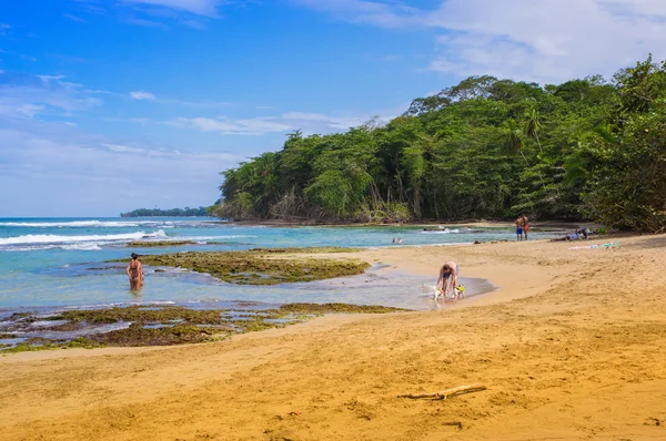 Puerto viejo, costa rica, 26. juni 2018: aussenansicht von unbekannten menschen, die baden und den sonnigen tag und das blaue wasser am strand von puerto viejo an der karibikküste genießen — Stockfoto