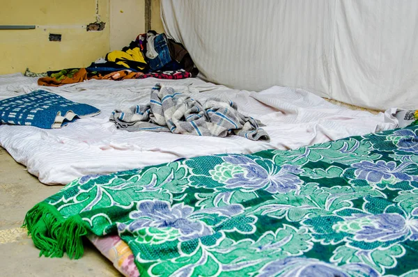 Close up di vestiti e accessori nel terreno di una stanza all'interno di un centro di rifugio nella città di Quito per le persone che fuggono dal loro paese Venezuela — Foto Stock
