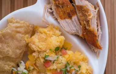 Ev yapımı püresi patates salatası, tostado, mote ve dilimlenmiş hornado parçaları ile yakın çekim