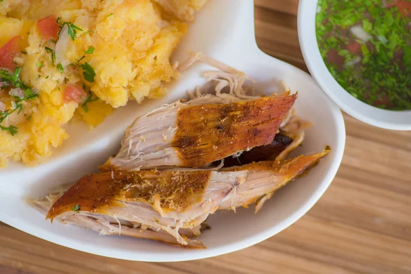 Close up of typical Andean food hornado inside of a white plate with mashed potatoes with salad — Stock Photo, Image