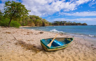 Bazı ağaçlarda Playa Montezuma mavi gökyüzü ve masmavi bir deniz ile güzel güneşli gün boyunca kumla küçük teknenin Playa Montezuma, Kosta Rika, Haziran, 28, 2018: açık görünüm