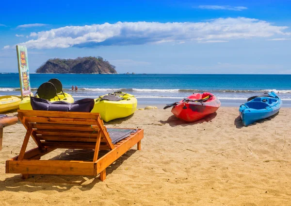 Samara, costa rica, 26. juni 2018: blick auf bunte kajaks am tropischen strand von samara im verleihgeschäft rady für unerschrockene touristen, die abenteuer lieben an einem herrlichen sonnigen tag — Stockfoto