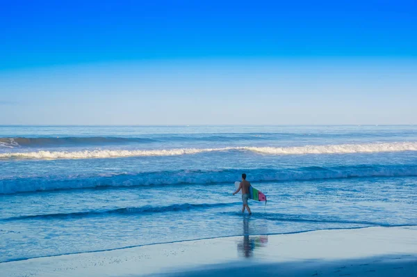 Santa teresa, costa rica - 28. juni 2018: ein jugendlicher spaziergang am strand von santa teresa mit seinem surfbrett bereit zum surfen an einem schönen sonnigen tag mit blauem himmel und blauem wasser — Stockfoto