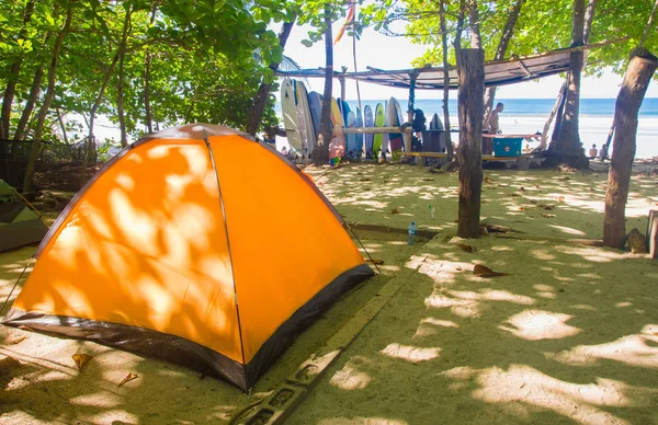 Santa Teresa, Costa Rica - June, 28, 2018: Outdoor view of orange camp tent for tourists with some surfboard in the background in the beach of Santa Teresa — стоковое фото