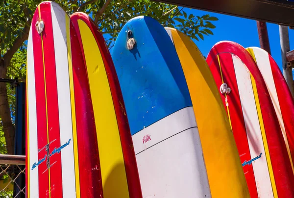 Tamarindo, Kostaryka, 26 czerwca 2018 r.: z bliska deska surfingowa stoi przed sklep wypożyczalnia w przepiękny słoneczny dzień i z niebieski niebo relaks tamarindo Beach — Zdjęcie stockowe