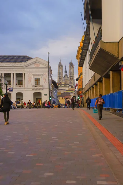 Quito, Ecuador - 2018. augusztus 24.: Azonosítatlan emberek séta a gyarmati utcában egy gyönyörű bazilika egyházi hátterű, a horizont, az Quito, Ecuador — Stock Fotó
