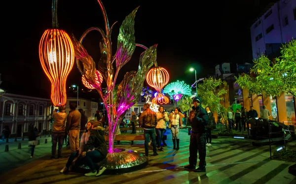 QUITO, ECUADOR- AUGUST, 15, 2018: Group of tourists taking pictures and selfies in La Guaragua street with some sculptures during the festival of lights of every August in the city of Quito — Stock Photo, Image